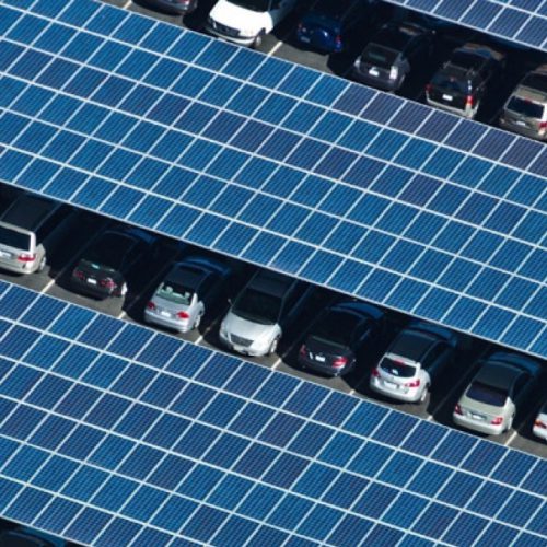 Cars parked under a canopy of solar panels.