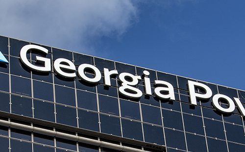 Georgia power logo on the side of a modern office building against a clear blue sky.