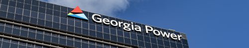 Georgia power logo on the side of a modern office building against a clear blue sky.