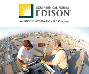 Two technicians working on electrical equipment on a rooftop with the southern california edison logo in the corner.