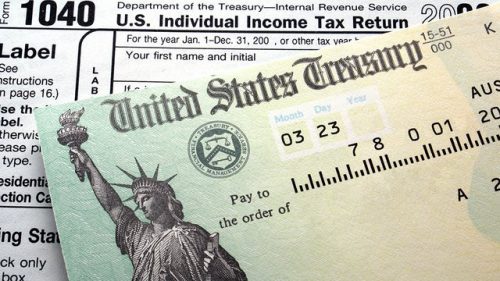 U.s. tax refund check placed on a 1040 tax form, featuring an image of the statue of liberty.