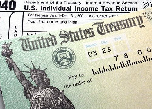 U.s. tax refund check placed on a 1040 tax form, featuring an image of the statue of liberty.