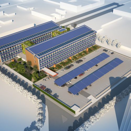 Aerial view of a modern industrial complex with solar panels on rooftops and in parking areas, highlighting sustainable energy use.