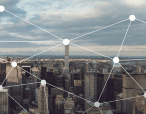 Aerial view of a city skyline with a digital overlay of white connecting dots and lines, symbolizing network connections.