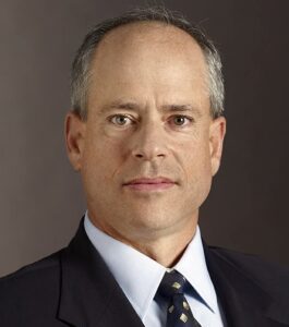 A man in suit and tie with short hair.