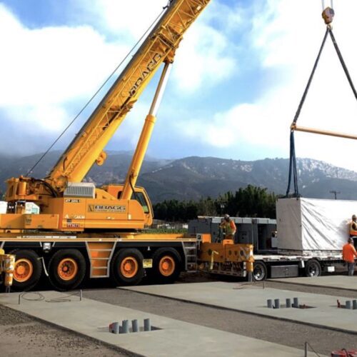A crane is being lifted by a truck.