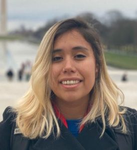 A woman with blonde hair standing in front of the washington monument.