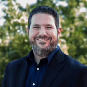 A man with a beard and suit jacket