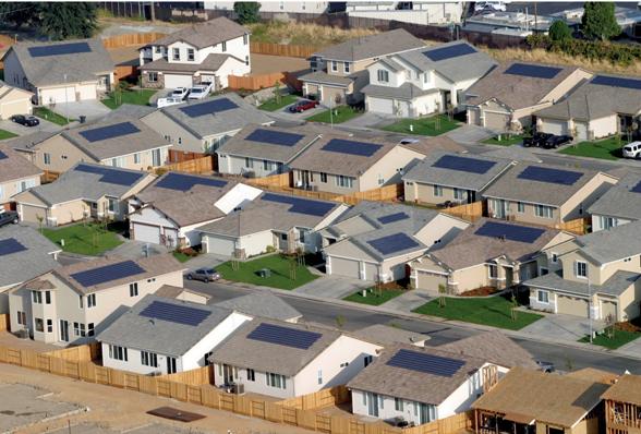 A view of many houses with solar panels on them.