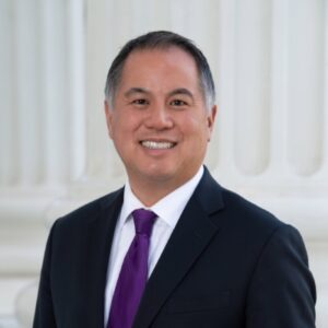 A man in a suit and purple tie.