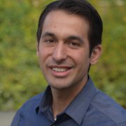 A man in blue shirt smiling for the camera.