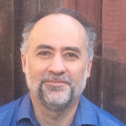 A man with a beard and mustache wearing blue shirt.