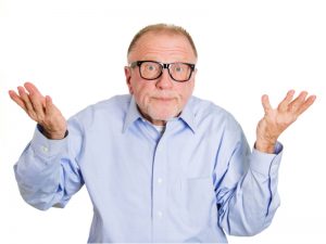 A man with glasses is holding his hands up.