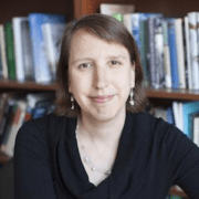 A woman in front of some books and shelves