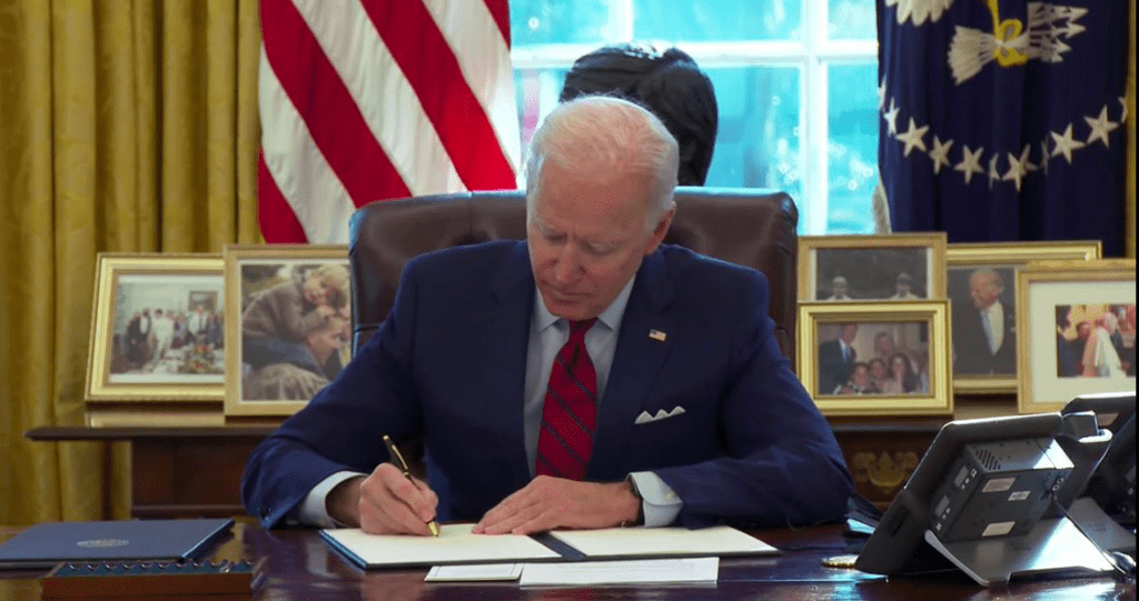 A man in a suit and tie sitting at a desk.