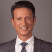 A man in suit and tie smiling for the camera.