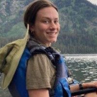 A woman in a life jacket on the water.