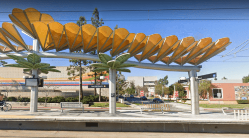 A yellow canopy over the sidewalk of a street.