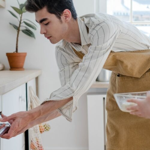 A man in an apron is holding something