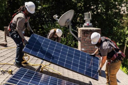 A group of men working on solar panels.