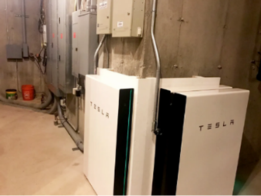 A bunch of tesla batteries are sitting in the middle of a room.