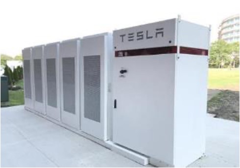 A large white tesla battery is shown on the sidewalk.