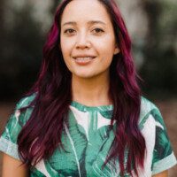 A woman with purple hair and a green shirt.