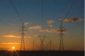 A group of power lines that are in the middle of a field.