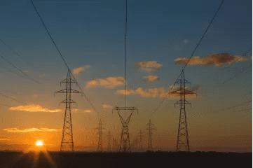 A group of power lines that are in the middle of a field.