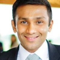 A man in a suit and tie smiling for the camera.