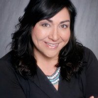 A woman with black hair and wearing a necklace.