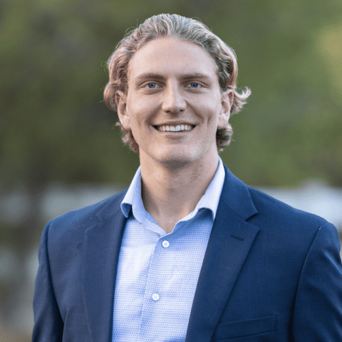 Smiling man in blue suit and shirt.