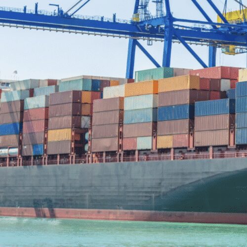Container ship at port with cranes unloading.