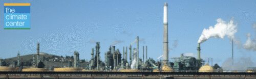 Industrial refinery with smokestacks under clear sky.