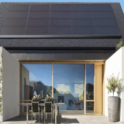 Modern house with solar panels and patio.