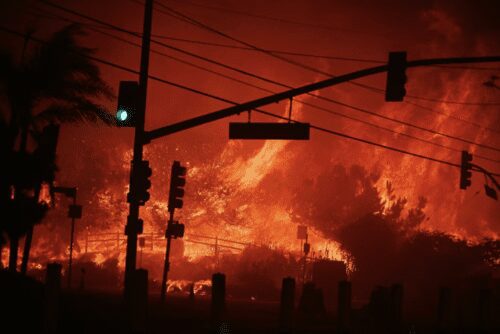 Wildfire raging behind traffic lights at night.